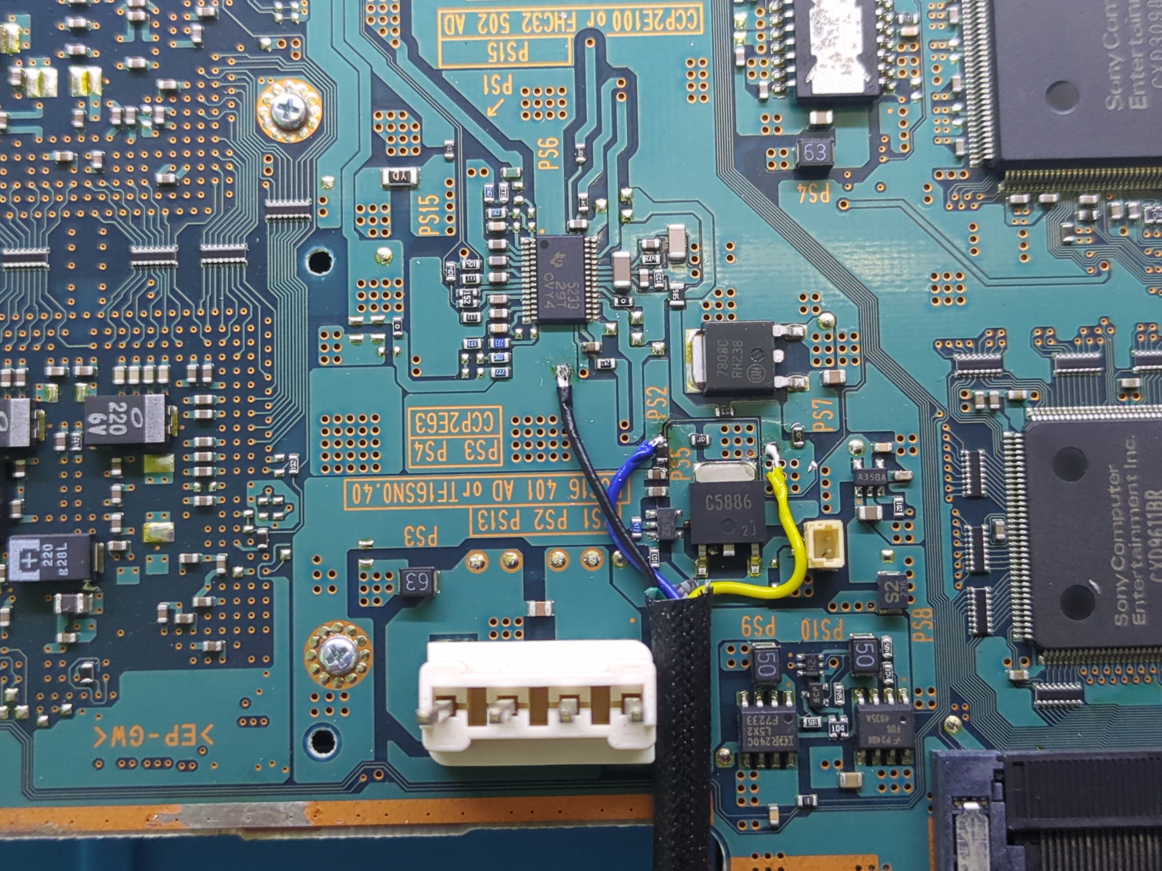 A fan cable soldered to the appropriate points on a PS2’s motherboard